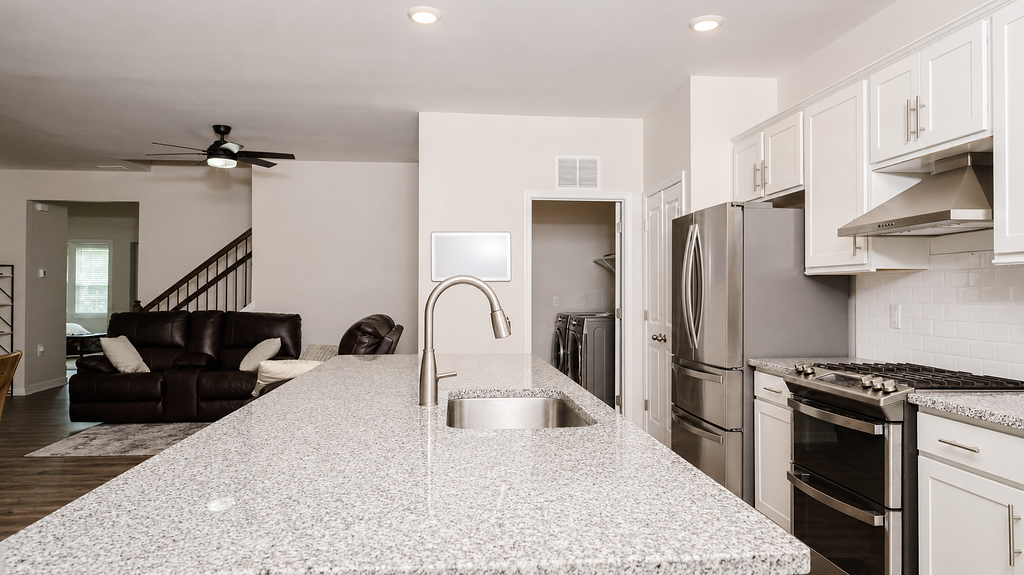 Kitchen with granite island, gas range and stainless appliances